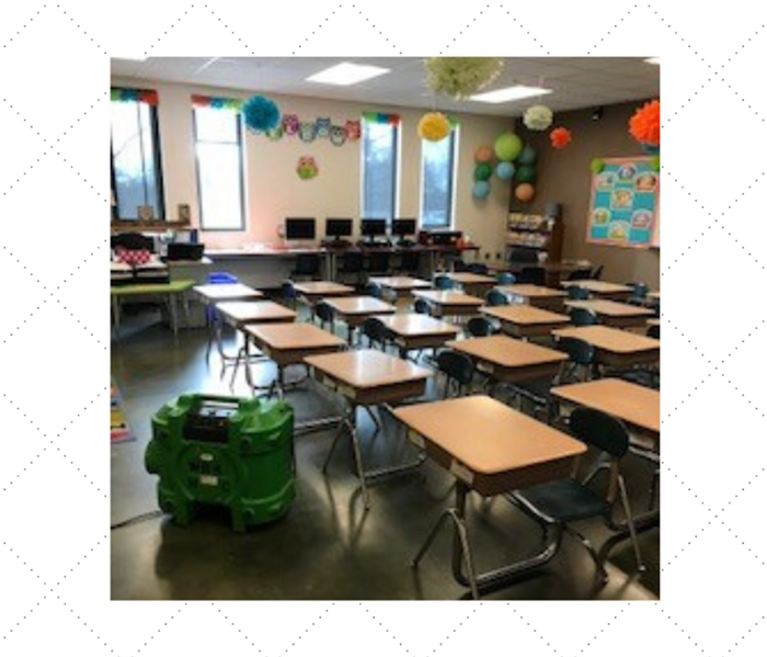 Classroom with desks lines up and a dehumidifier on the ground 